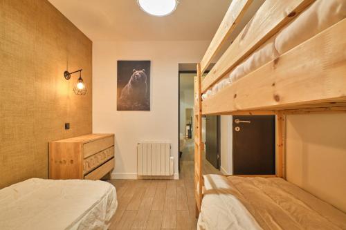 a bedroom with a bunk bed and a dresser at Marmotte 104 in Les Deux Alpes