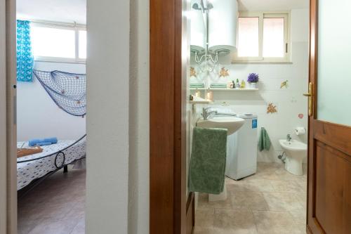 une salle de bains avec lavabo et toilettes dans l'établissement La Casa Al Mare, à Castelsardo