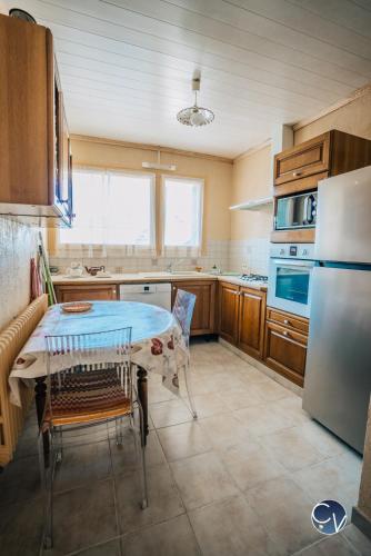 une cuisine avec une table et un réfrigérateur dans l'établissement Beautiful air-conditioned and bright apartment, à Bollène