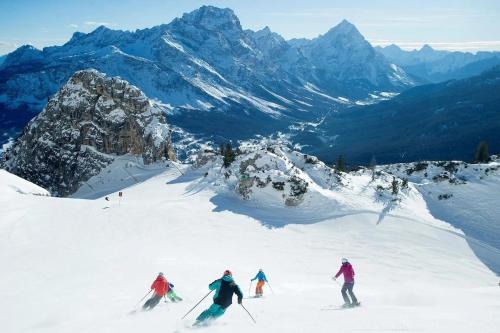 a group of people skiing down a snow covered mountain at Cervo Felice Apartment in Belluno