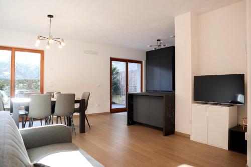 a living room with a couch and a table with chairs at Cervo Felice Apartment in Belluno