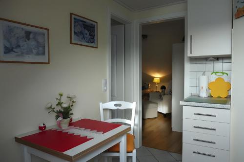 une cuisine avec une table et un comptoir rouge dans l'établissement Ferienwohnung Neumann, à Wesselburen