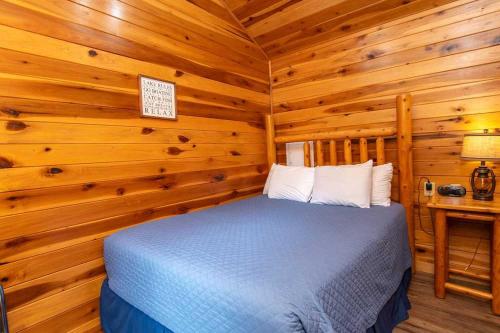 a bedroom with a bed in a log cabin at Port of Kimberling Resort & Campground in Kimberling City