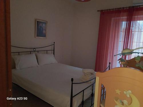 a bedroom with a bed and a window at Menidi apartment Β in Menídion