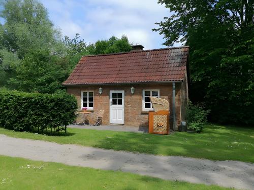 a small brick house with a red roof at Backhaus in Karolinenkoog