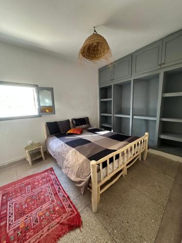 una camera con un letto e un tappeto di DAR SANAE SURF ad Aourir