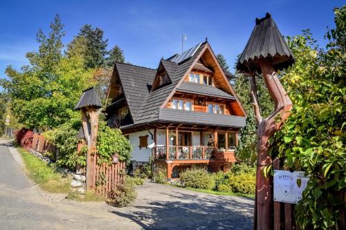 a wooden house with a black roof at U Pabinów in Kościelisko