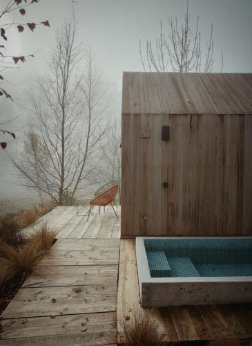 a wooden building with a bench on a wooden deck at MU_MORADAS NO ULLA in Teo