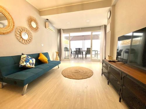 a living room with a blue couch and a television at Casa Mané - Central apartment in Carvoeiro in Carvoeiro
