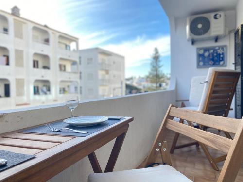 a table with a glass of wine on a balcony at Casa Mané - Central apartment in Carvoeiro in Carvoeiro