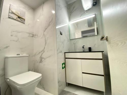 a white bathroom with a toilet and a sink at Casa Mané - Central apartment in Carvoeiro in Carvoeiro