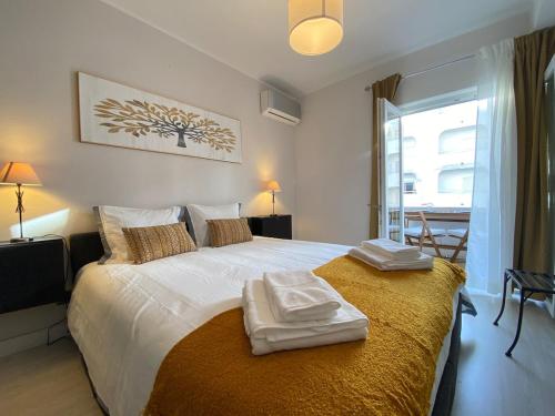 a bedroom with a bed with two towels on it at Casa Mané - Central apartment in Carvoeiro in Carvoeiro