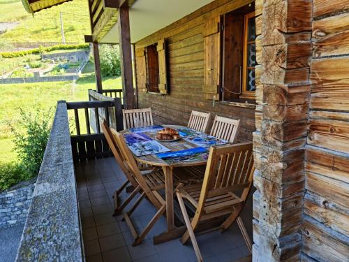 - une table et des chaises sur la terrasse couverte d'une cabine dans l'établissement Chalet Genépi, au Grand-Bornand