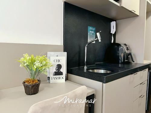 a kitchen with a sink and a black wall at Move - Tambaú in Tambaú