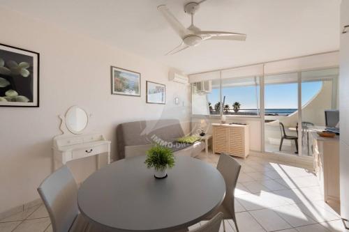 une salle à manger et un salon avec une table et des chaises dans l'établissement As21522 - P2 climatisé avec belle vue sur la Mer avec piscine et parking privé, au Grau-du-Roi
