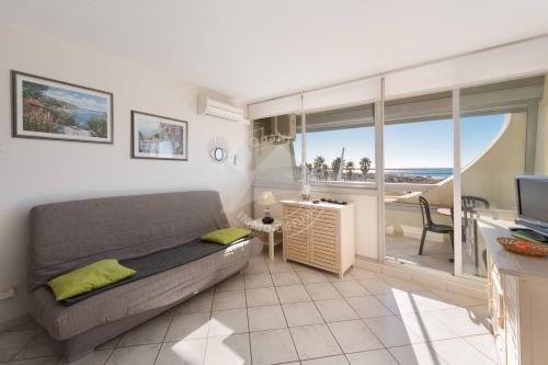 d'un salon avec un canapé et un balcon. dans l'établissement As21522 - P2 climatisé avec belle vue sur la Mer avec piscine et parking privé, au Grau-du-Roi