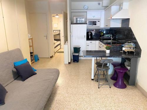 une cuisine et un salon avec une table et un canapé dans l'établissement AS21515 - Studio cabine avec joli jardin et parking privé, au Grau-du-Roi