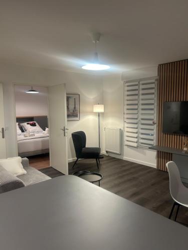 un salon avec un lit, une table et des chaises dans l'établissement Central Disney apartment, à Chessy
