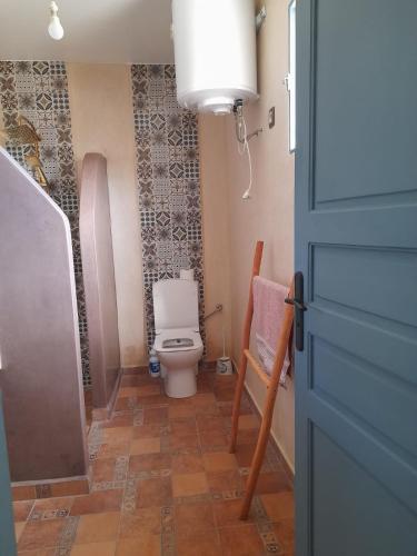 a bathroom with a toilet and a chair at le Doux refuge 2 in Essaouira