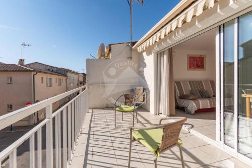 - un balcon avec des chaises et un canapé dans un bâtiment dans l'établissement AS21487 - Charmant studio au cœur du centre ville à 2 pas de la plage, au Grau-du-Roi