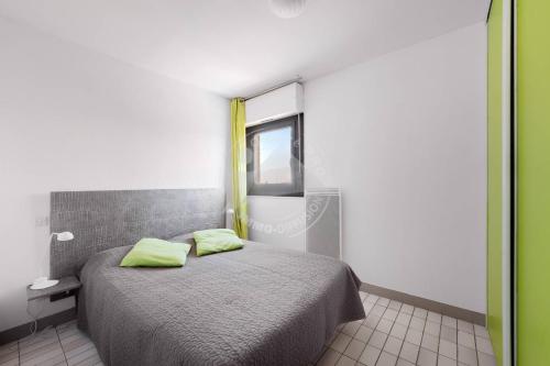 - une chambre avec un lit et 2 oreillers vert citron dans l'établissement AS21388 - P2 avec vue dégagée et arborée avec parking privé, au Grau-du-Roi