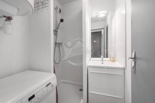 une salle de bain blanche avec un lavabo et une douche dans l'établissement AS21388 - P2 avec vue dégagée et arborée avec parking privé, au Grau-du-Roi