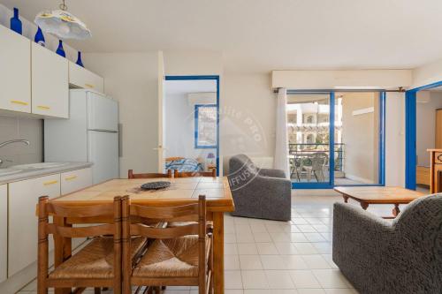 une cuisine et une salle à manger avec une table et des chaises dans l'établissement AS21491 - P3 Cabine en bord de mer avec vue mer latérale, au Grau-du-Roi
