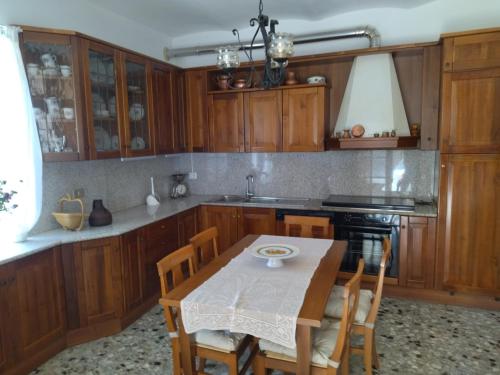 a kitchen with wooden cabinets and a table with chairs at A Casa di Marietta in Ari