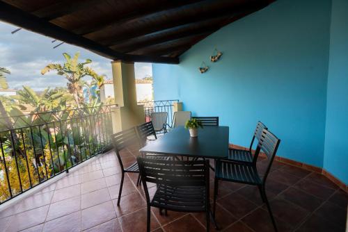 a table and chairs on a balcony with a blue wall at Borgo Degli Ulivi in Àrbatax