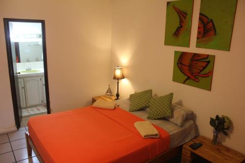 a bedroom with a bed with an orange blanket at Casa Areka in Panama City