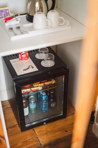 a small cabinet under a table with drinks and glasses at Hotel Edouard VII in Biarritz