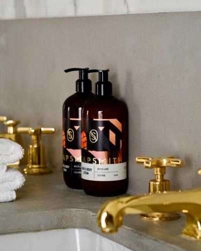 a bottle of soap sitting next to a bathroom sink at Hart Shoreditch Hotel London, Curio Collection by Hilton in London