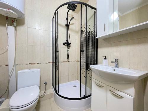 ein Badezimmer mit Dusche, Toilette und Waschbecken in der Unterkunft Apartament in Chişinău
