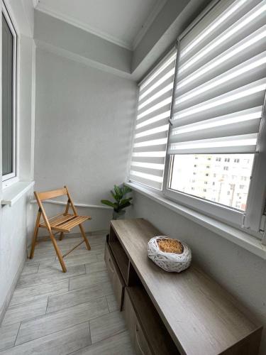 ein Raum mit einem Fenster mit einer Bank und einem Stuhl in der Unterkunft Apartament in Chişinău