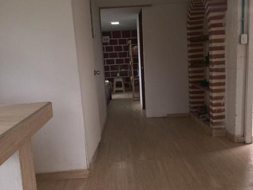 an empty room with a hallway with a brick wall at Hostal Las Hamacas , Entre Montañas y Luces in Villamaría