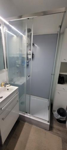 une salle de bain avec une douche en verre et un lavabo dans l'établissement 50m DE LA PLAGE, CLIM, JOLI APPARTEMENT 6p, SECTEUR GRANDE PLAGE, au Barcarès