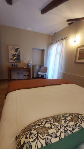 a bedroom with a bed and a desk and a chair at La Giolitta Accomodations in Barolo