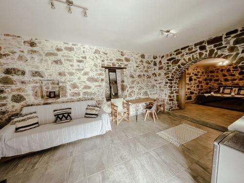 a bedroom with a bed and a stone wall at Lefteris Rooms in Kámbos