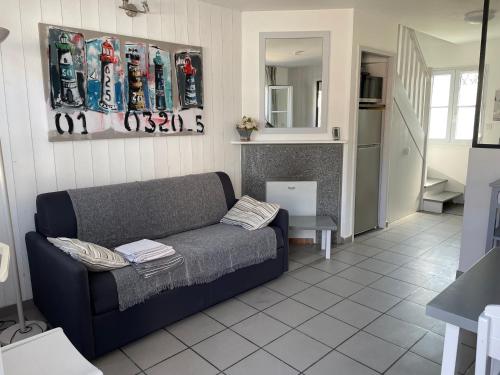 - un salon avec un canapé et des skis sur le mur dans l'établissement Belle maison dans résidence avec piscine, à La Flotte