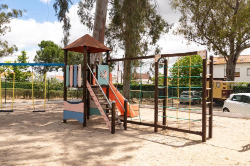 a playground with a slide in a park at Parque de Campismo Orbitur Evora in Évora
