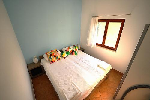 a bedroom with a white bed with colorful pillows at Adriatic Vacation House in Ližnjan