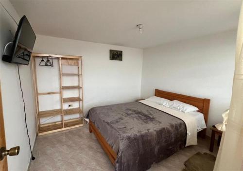 a bedroom with a bed and a television in it at Güicani Hostel in Güicán