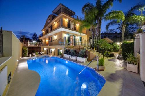 a house with a large swimming pool in front of it at Appartamento Athena in villa 4pax in Marina di Ragusa