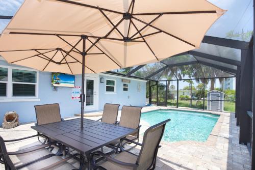 a patio with a table and chairs with an umbrella at Ocean Breeze by Sun Palace Vacations in Fort Myers Beach