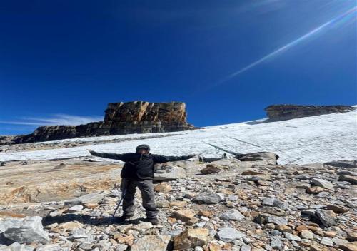 a man standing on a mountain with his arms out at Güicani Hostel in Güicán