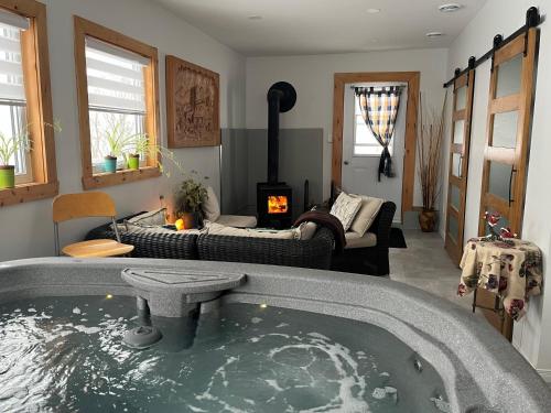 a bath tub in a living room with a fireplace at La maison du petit rang in Saint-Éloi