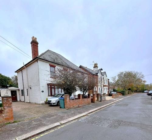 an old white house on the side of a street at Cromwell Suite in Basingstoke