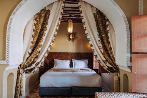 a bedroom with a bed with a staircase in the background at Riad Ksar Al Amal & Spa in Marrakech