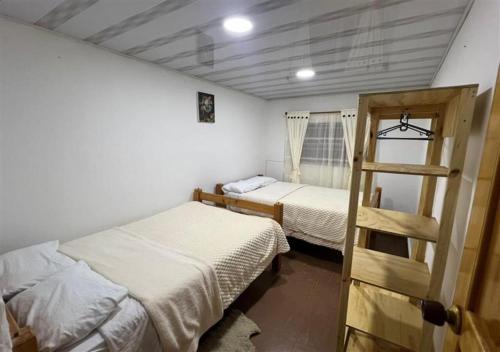 a room with two beds and a ladder in it at Güicani Hostel in Güicán