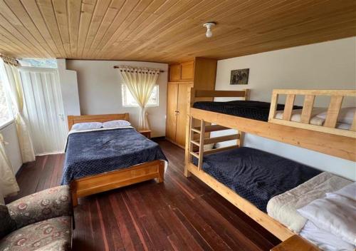 a bedroom with two bunk beds and a couch at Güicani Hostel in Güicán
